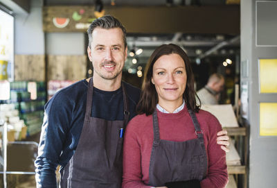 Portrait of confident entrepreneurs standing in store