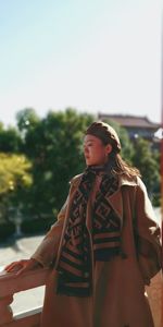 Portrait of young woman standing against lake