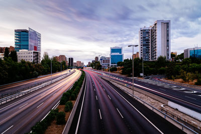 Highway amidst buildings in city against sky