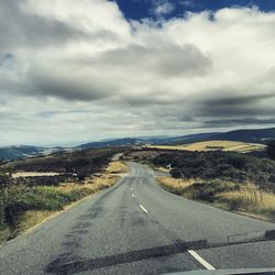 Empty road along countryside landscape