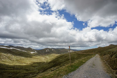 Scenic view of road by mountains against sky