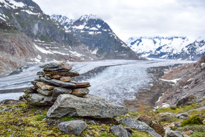 Aletsch glacier in the bernese alps in switzerland. a stoneman - rock cairn - in the foreground.