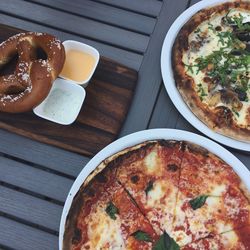 Directly above shot of pizza and pretzel on table