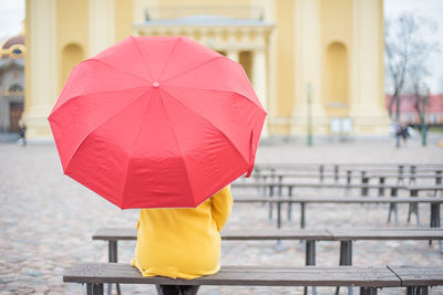 Rear view of yellow umbrella walking in rain