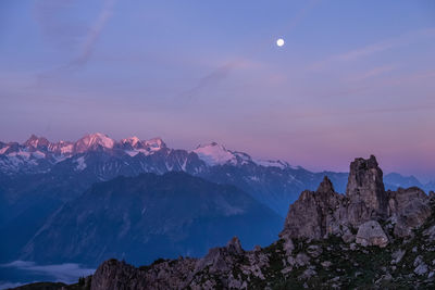 Scenic view of snowcapped mountains against sky at night