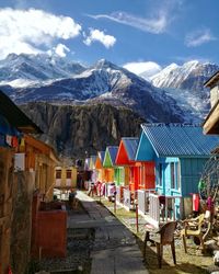 Houses by mountains against sky