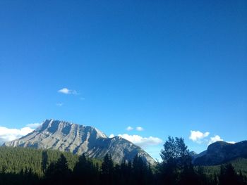 Scenic view of mountains against blue sky