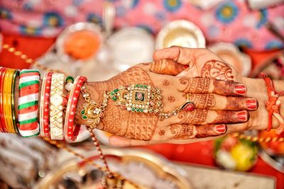 Cropped hands of bride and bridegroom with heena tattoo