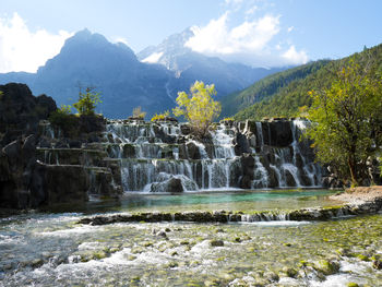 Scenic view of waterfall against mountain