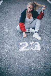 High angle portrait of young woman on road