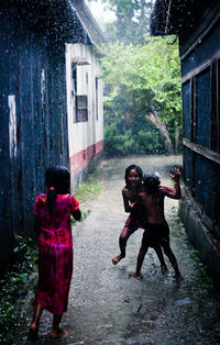 Rear view of people standing on wet building