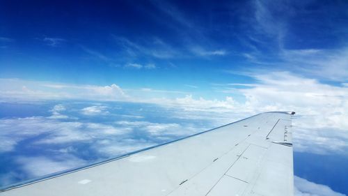 Airplane wing against blue sky