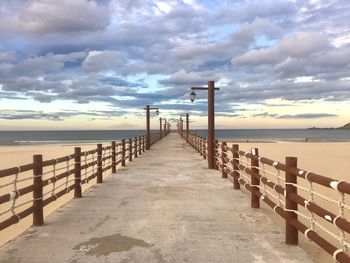 Wooden pier on sea against sky