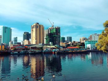 Reflection of buildings in city against sky