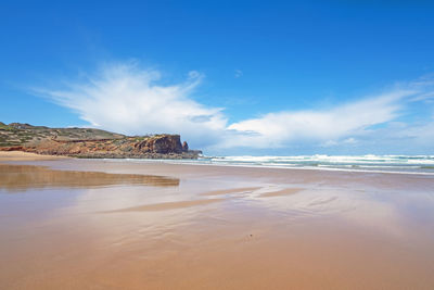 Scenic view of beach against blue sky
