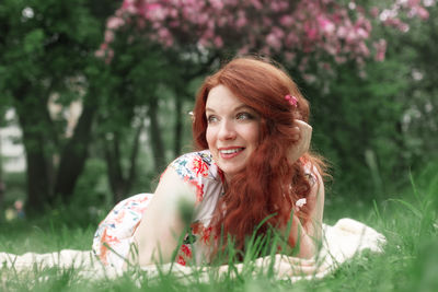 Portrait of young woman sitting on field