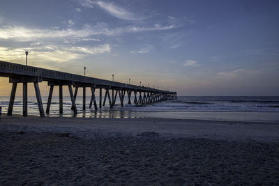 Pier over sea against sky during sunset