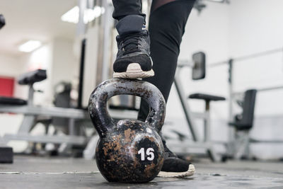 Low section of person with kettlebell standing in gym