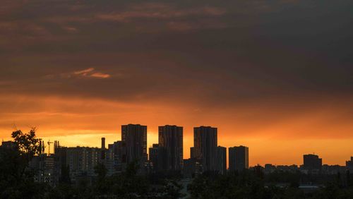 Silhouette buildings against sky during sunset