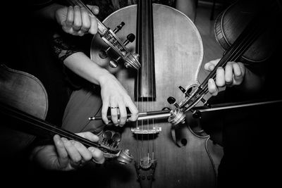 Midsection of musicians playing cello and violins