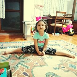 Portrait of cute girl sitting on floor at home