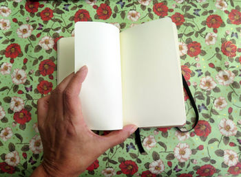 Midsection of person holding book