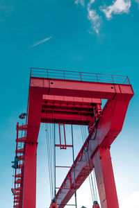 Low angle view of crane against blue sky