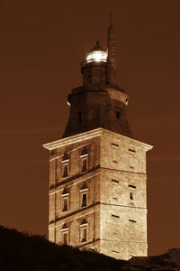 Low angle view of clock tower against sky at night