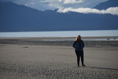 Full length of man standing on beach against sky