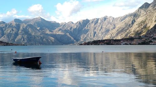 Scenic view of lake by mountains against sky