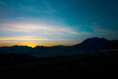 Scenic view of silhouette mountains against sky at sunset