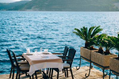 Chairs and tables by swimming pool at beach