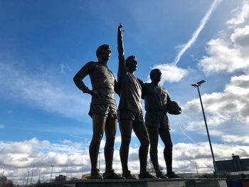 Low angle view of statue against sky, george best, bobby charlton, denis law, manchester united