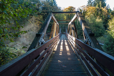 Footbridge amidst trees in forest