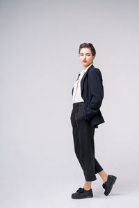 Attractive business young woman posing in business black suit with short