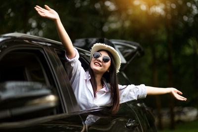 Young woman wearing sunglasses while sitting in car