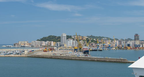 Scenic view of sea by buildings against sky