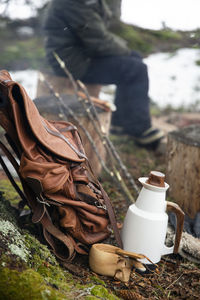 Backpack kept by jug and wooden cup