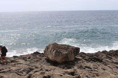 Rocks on beach against sky