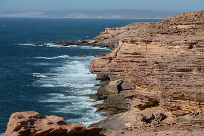 Rock formations on shore against sky