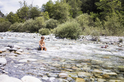 Man standing on rock by river