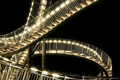 Low angle view of illuminated bridge at night