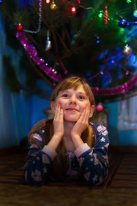 Portrait of cute girl sitting on sofa at home