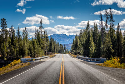 Road amidst trees against sky