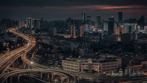 High angle view of illuminated city buildings against sky