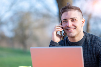 Smiling businessman talking on smart phone