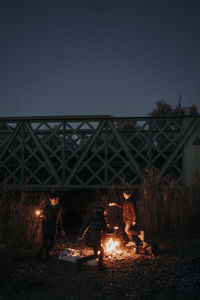 Group of young friends camping and burning a wood fire