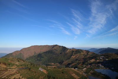 Scenic view of landscape and mountains against blue sky