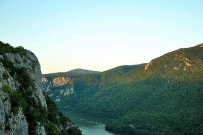 Scenic view of river and mountains against clear sky