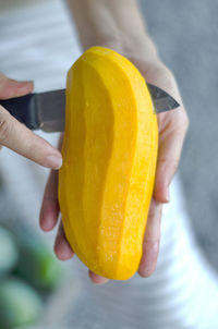 Ripe mango. woman using a knife to peel ripe fruit, yellow, fragrant and sweet.